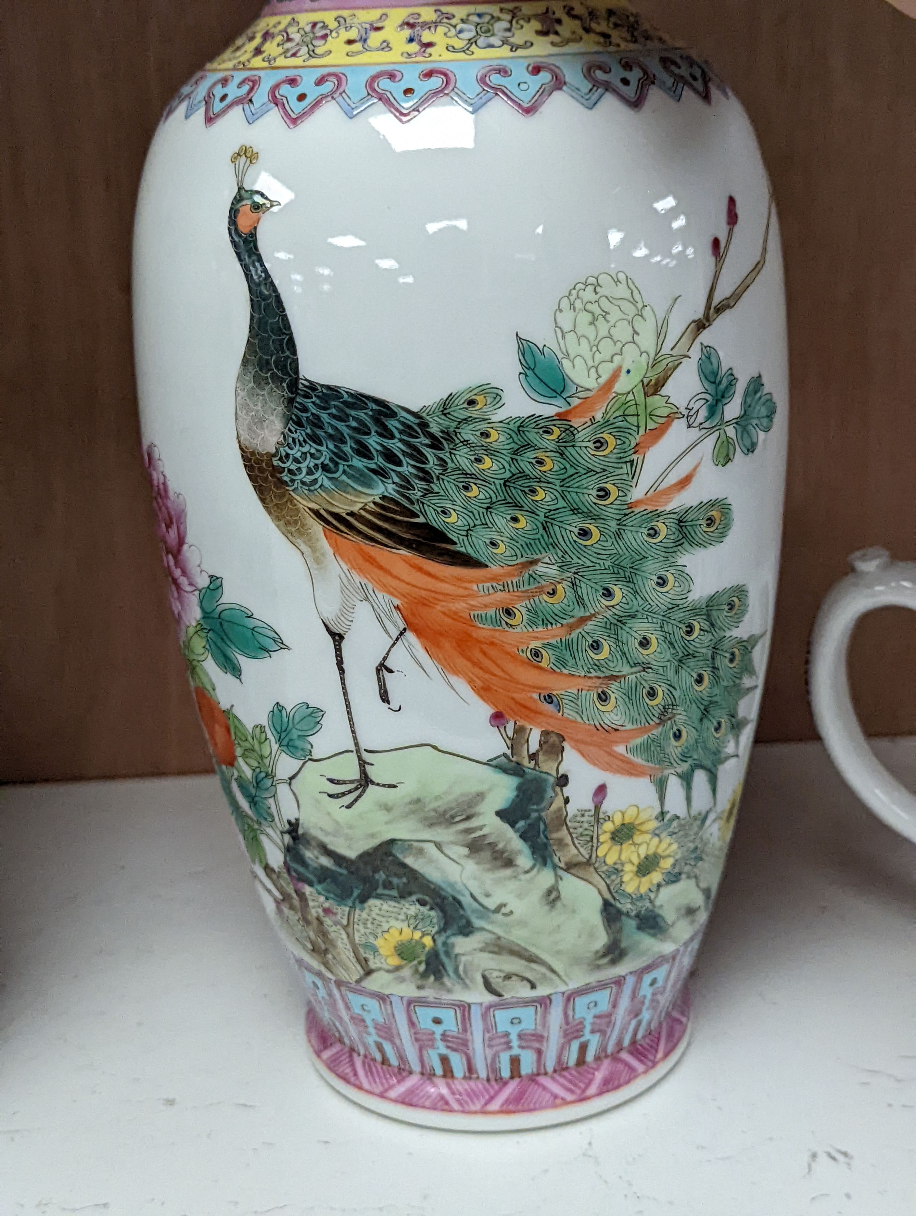 A pair of Chinese famille rose vases decorated with peacocks, 31cm